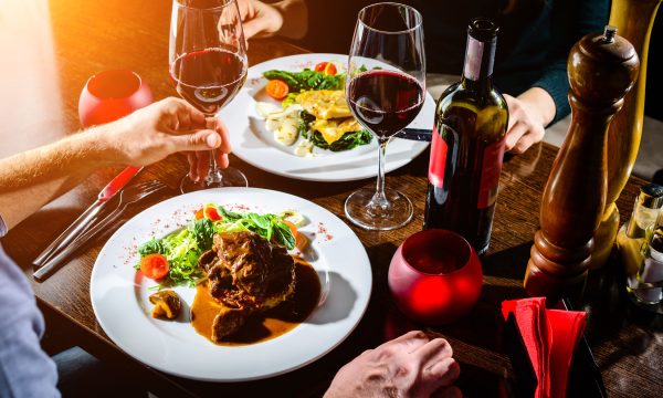 Couple having romantic dinner in a restaurant in rays of the sun Couple having romantic dinner in a restaurant in rays of the sun
