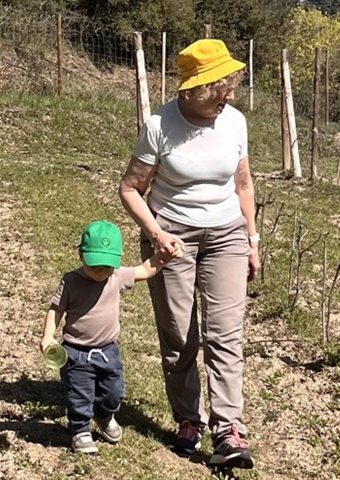 Àvia de Can Feliu passejant de la mà del seu net entre els ceps de la vinya